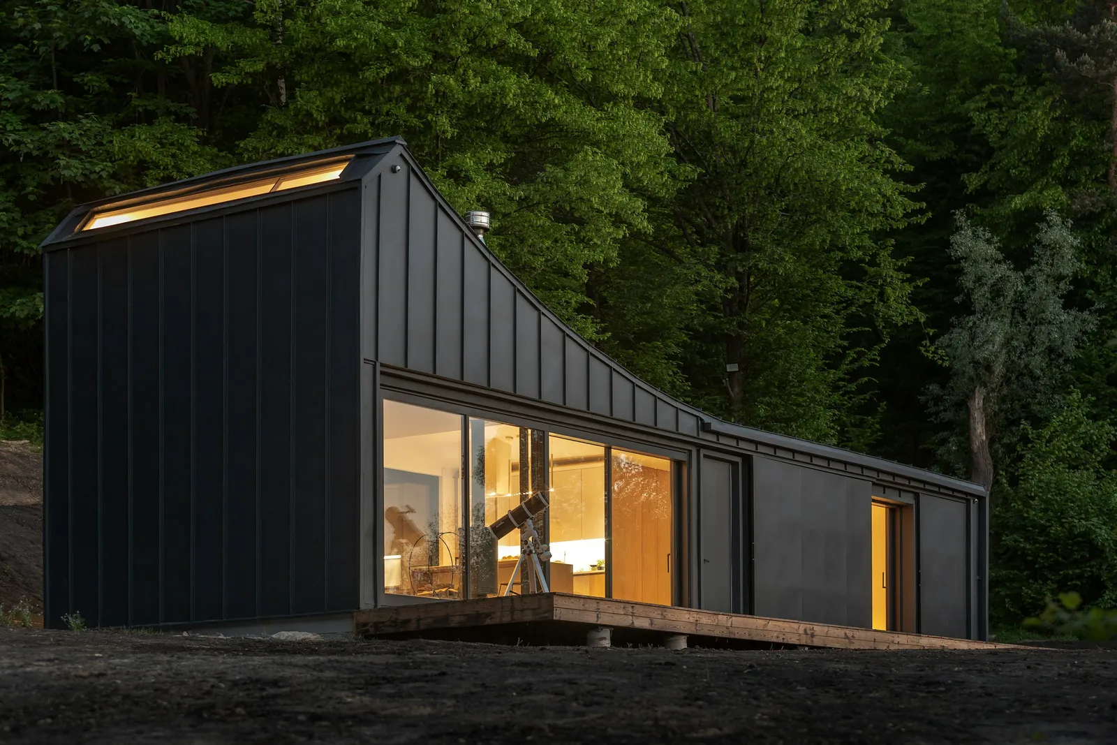 Prefabricated cabin with timber deck at dusk