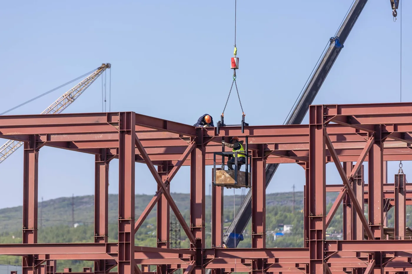 Structural steel frame being lifted into place by crane
